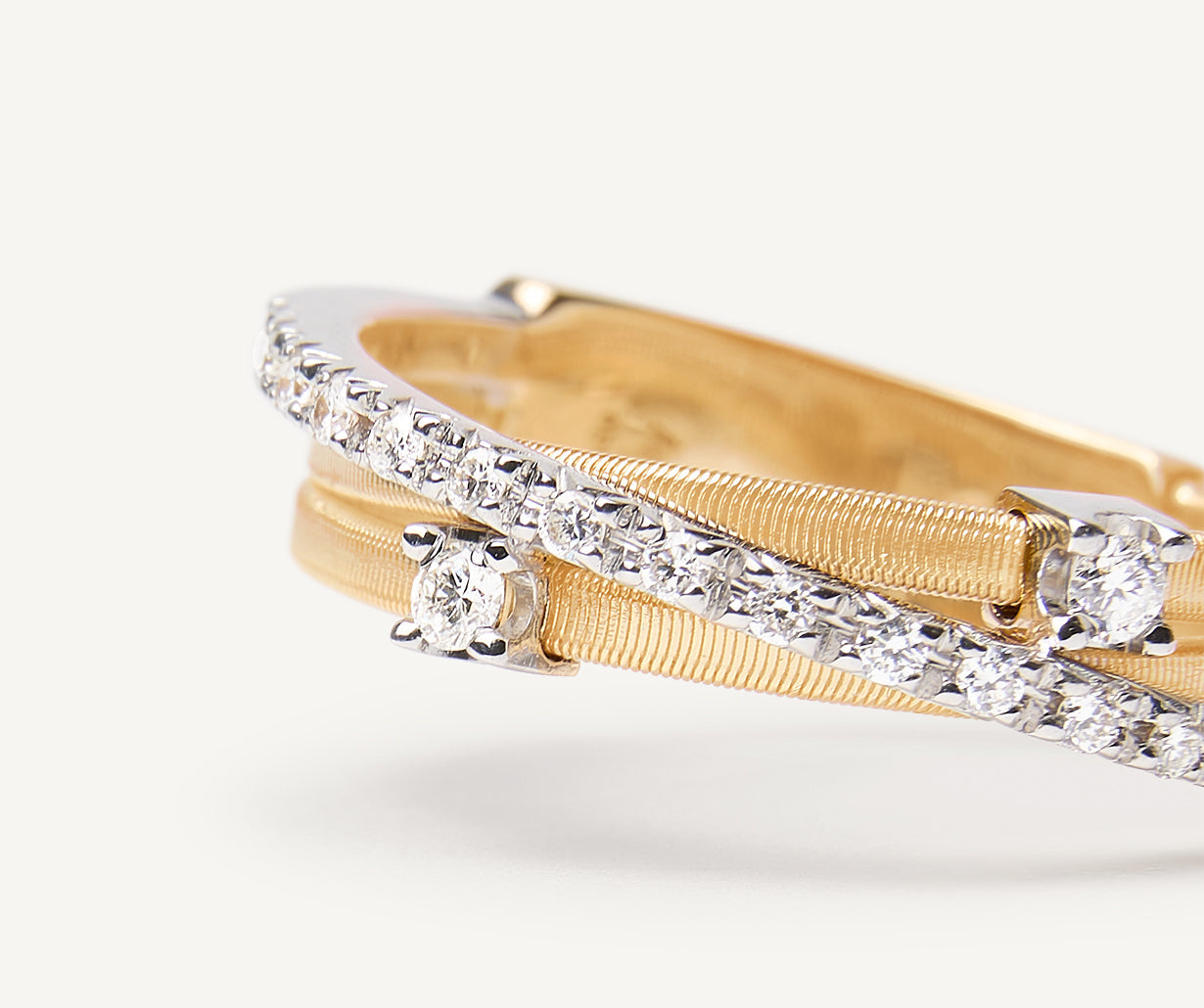 Three-band ring with prong-set diamonds and a diamond-studded plaque